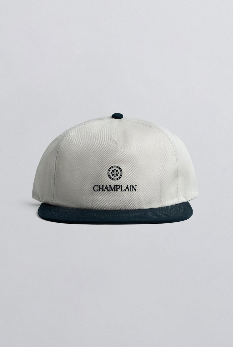 Champlain Cream on Navy Hat featuring 5-panel design with contrasting navy embroidery and adjustable snapback closure.