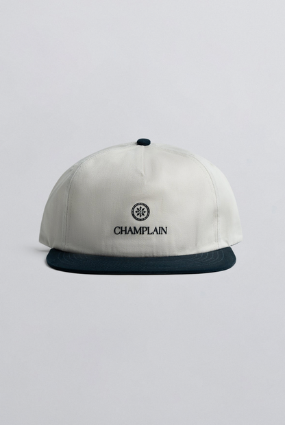 Champlain Cream on Navy Hat featuring 5-panel design with contrasting navy embroidery and adjustable snapback closure.