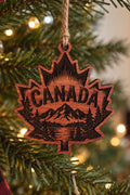 Two Makers Crew Canada Maple Leaf Christmas Ornament — Maple-leaf shape with CANADA lettering, mountains and evergreens