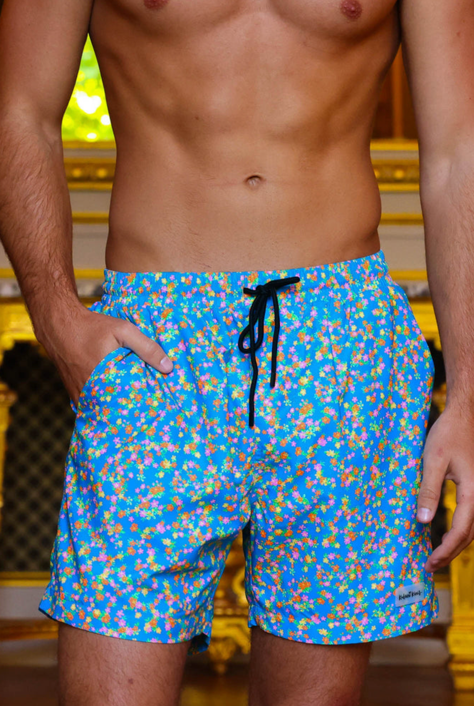 Close-up of men's La Belle swim shorts showing waistband, floral fabric, and stitching detail