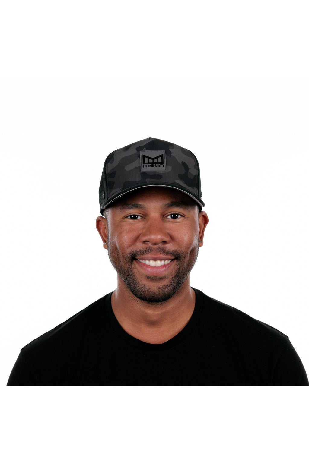 Model wearing the melin Odysea Stacked Hydro performance snapback hat in Black Camo