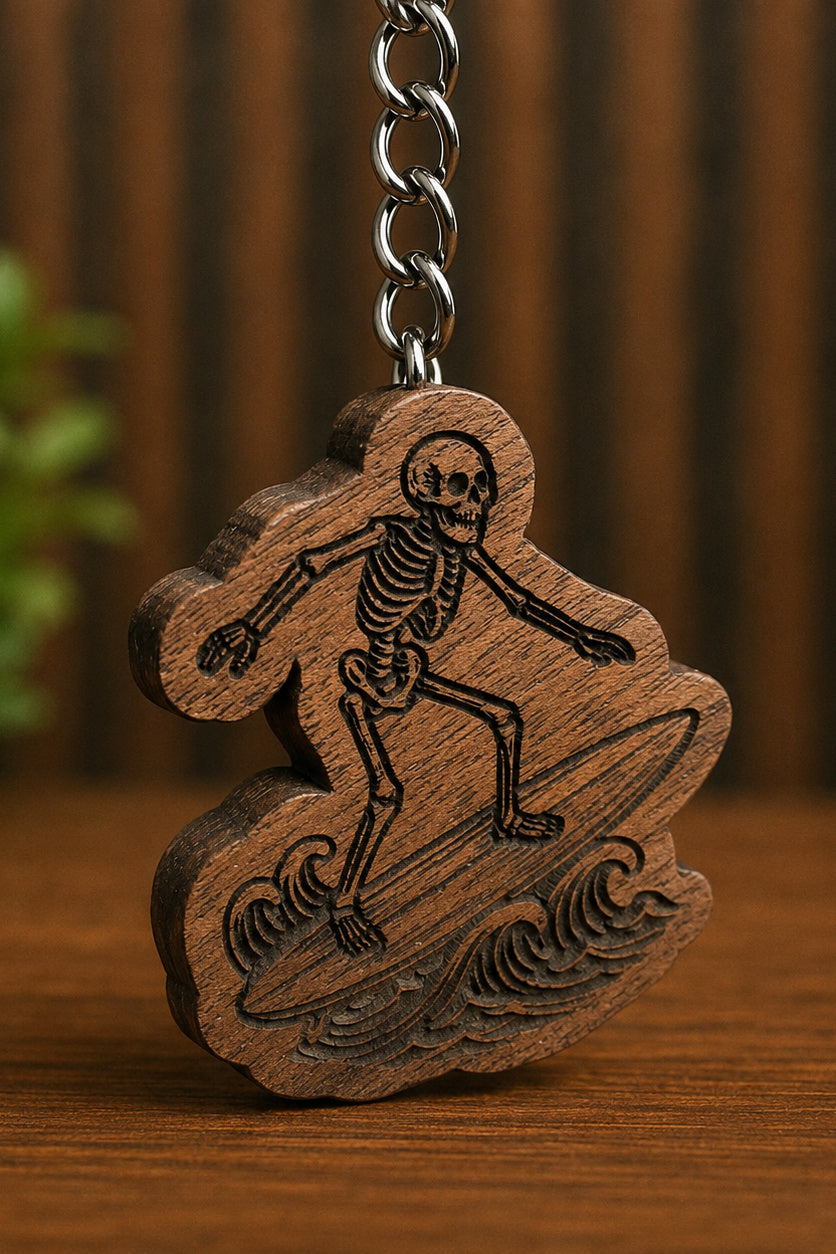 Two Makers Crew Surfer Die Keychain — Engraved skeleton surfing a wave