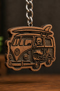 Two Makers Crew Surfer Van Keychain — Camper-van silhouette with roof-mounted surfboard, skeleton driver and wave artwork